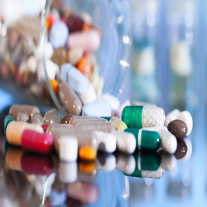 Colorful tablets with capsules and pills on blue background